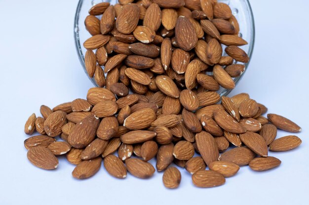 Photo amandes dans un bol en porcelaine blanche sur une table en bois concept d'amande avec copyspaceamande noix d'amande isolée tranche d'amande pleine profondeur de champ