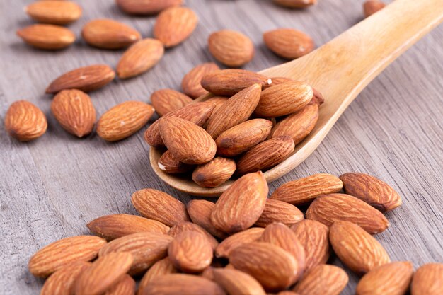 Amandes dans une cuillère en bois sur la table