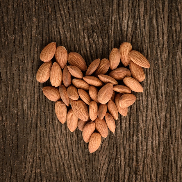 Amandes en forme de coeur sur fond de bois