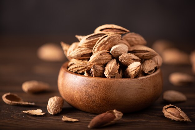 Amandes fraîches en coque dans un bol en bois