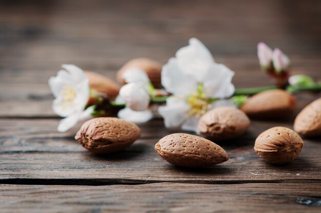 Photo amandes fraîches et fleurs sur la table en bois