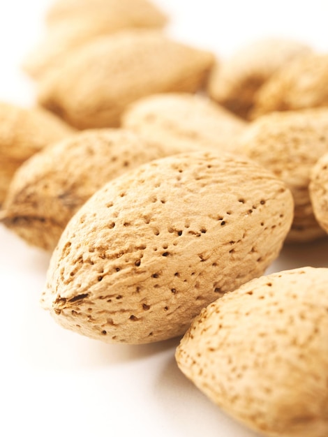 Amandes avec pelure sur fond blanc