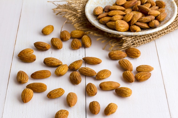 Amandes avec plat sur la table en bois.