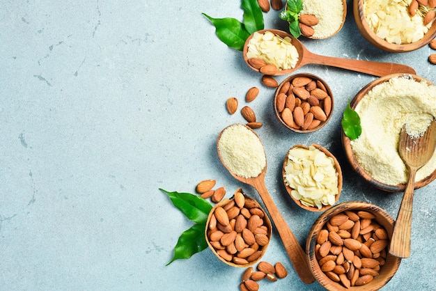 Amandes rôties, flocons d'amande et farine d'amende sur un fond en béton clair Espace libre pour le texte