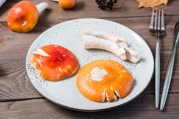 Amanite crue hachée prête à manger sur une assiette sur une table en bois. Microdosage et médecine alternative. Fermer