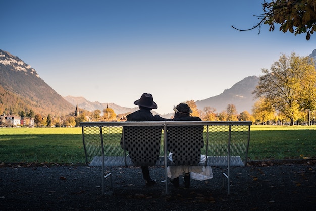 Amant assis par la montagne contre le ciel en Suisse