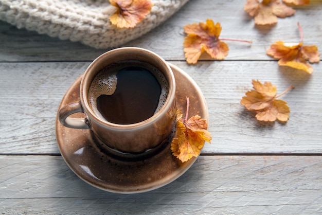 Ambiance d'automne Ambiance d'automne Une tasse de café une écharpe tricotée des livres et des feuilles d'automne sur le rebord de la fenêtre