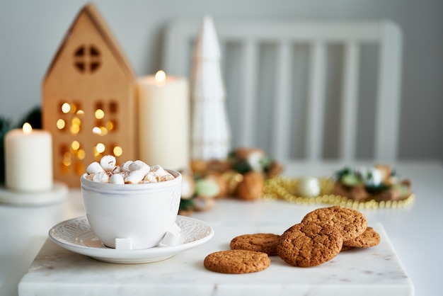 Ambiance de Noël dans le salon des biscuits aux pépites faits maison et une tasse de chocolat chaud