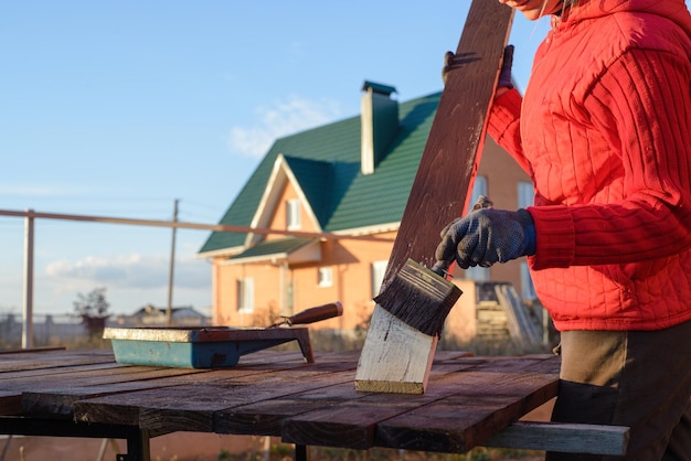 Amélioration de l'habitat bricoleuse peinture planche de bois à l'extérieur