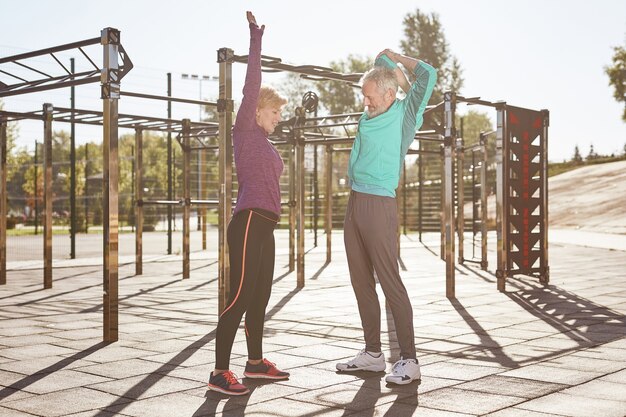 Améliorer la santé d'un couple familial mature actif et sain en vêtements de sport faisant des exercices du matin