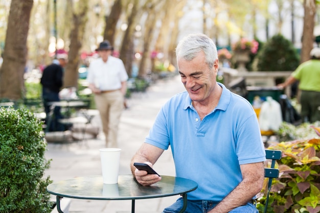 Américain Senior homme avec téléphone portable au parc