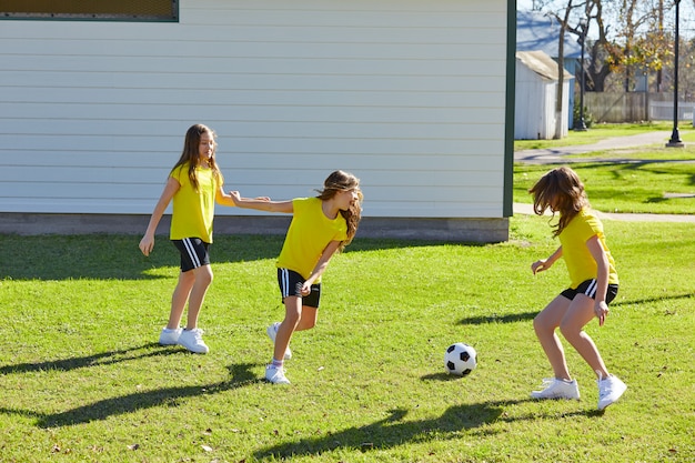 Ami filles adolescentes jouant au football football dans un parc