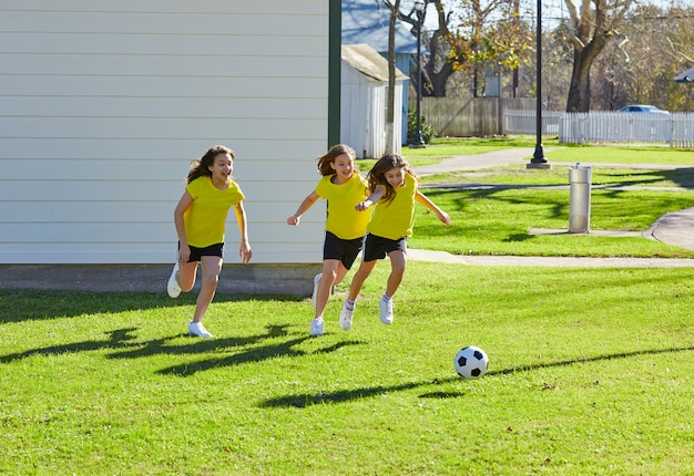 Ami filles adolescentes jouant au football football dans un parc