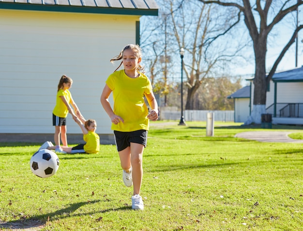 Ami filles adolescentes jouant au football football dans un parc