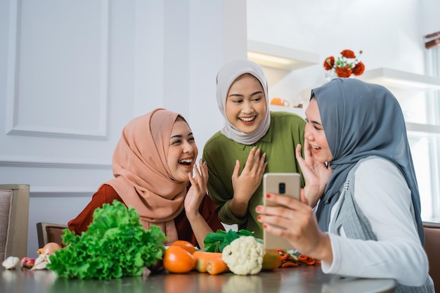 Ami avec hijab regardant le téléphone pour faire de la nourriture