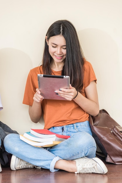 Amie de jeunes filles assise en utilisant la technologie à l'université