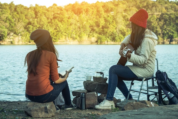 Des amies assises au bord du lac.