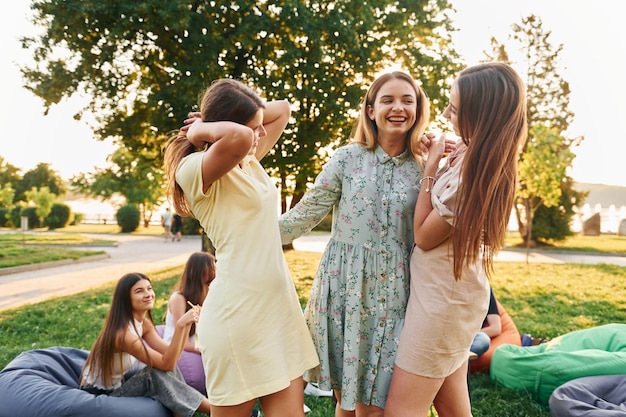 Amies debout et s'amusant Groupe de jeunes font la fête dans le parc pendant la journée d'été