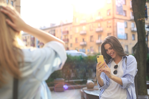 Des amies heureuses se prennent en photo dans la ville.