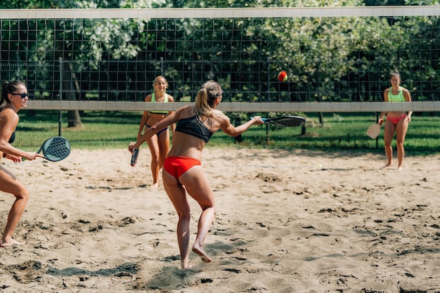 Amies jouant au tennis de plage