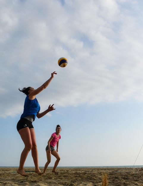 Des amies jouant au volley-ball sur la plage.