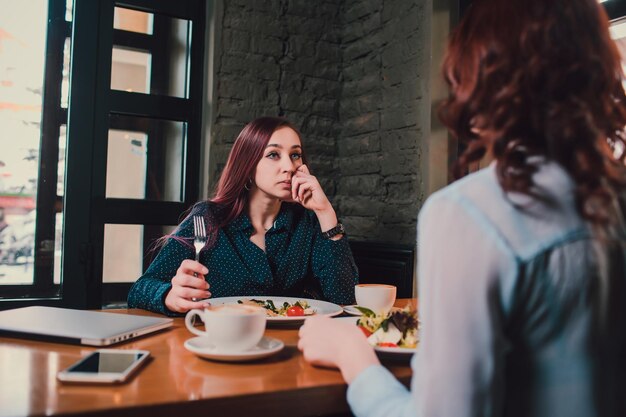 Photo des amies lgbt gaies discutant dans un café deux belles jeunes femmes qui bavardent et boivent du café concept d'amitié