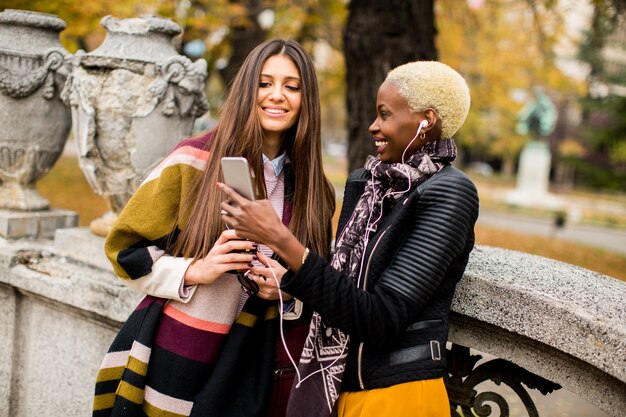Amies multiraciales prenant selfie en plein air