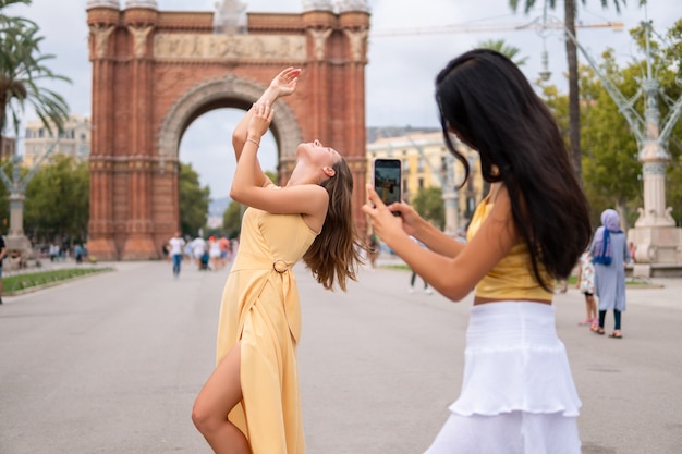 Amies prenant des photos près d'une attraction urbaine