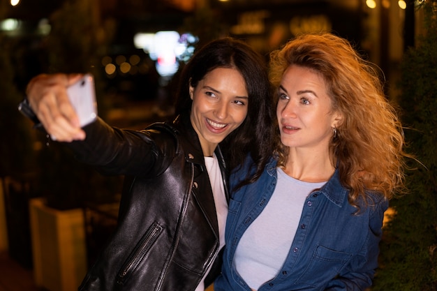 Photo amies prenant un selfie pendant une soirée