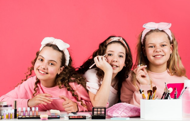 Des amies souriantes s'amusent à la fête du salon de beauté du spa. portrait de beauté de trois enfants au maquillage naturel et à la peau saine. bonne fête des enfants. trois amis au visage heureux. Rose fou.