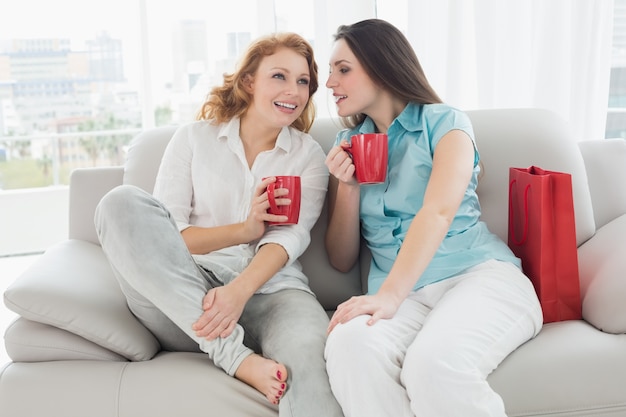 Amies avec des tasses de café converser à la maison