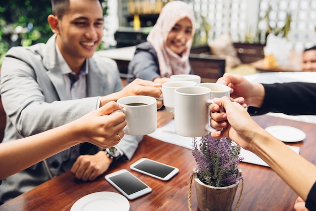 Amis d'affaires acclamant avec café au café