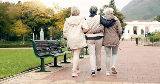 Des amis âgés qui parlent et se promènent ensemble sur un sentier en plein air pour se détendre dans la nature avec des femmes âgées à la retraite Des gens heureux qui pointent et conversent dans le parc ou dans les bois en automne ou en hiver
