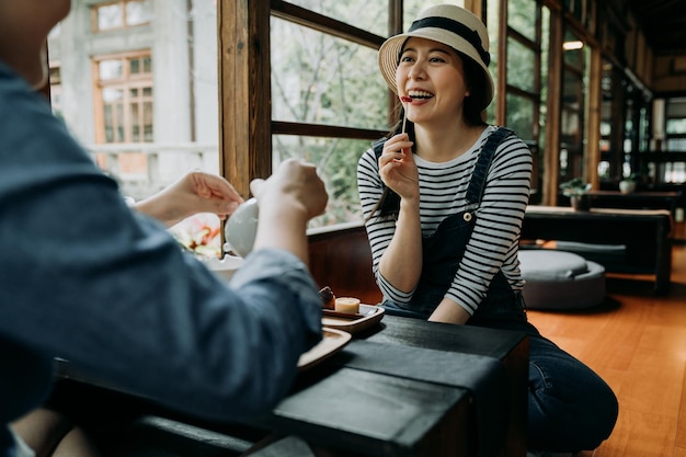 Amis assis faisant la cérémonie du thé sur la table