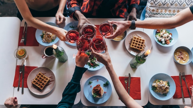 Amis assis à une table buvant des verres à vin.