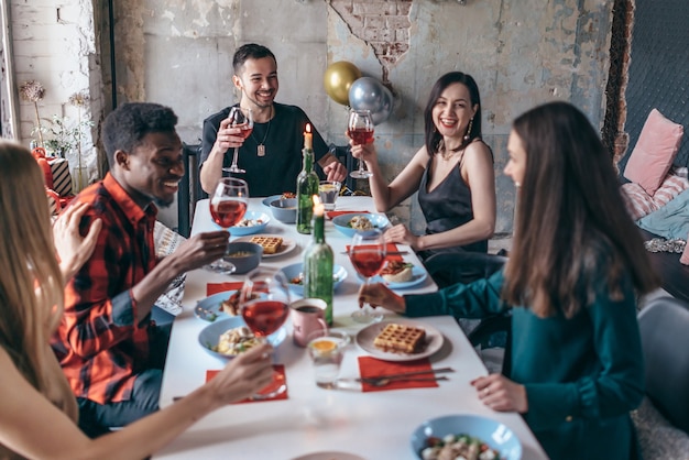 Amis assis à une table buvant des verres à vin.