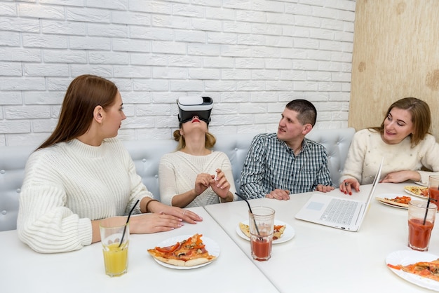 Amis au café mangeant de la pizza et essayant des lunettes virtuelles 3d