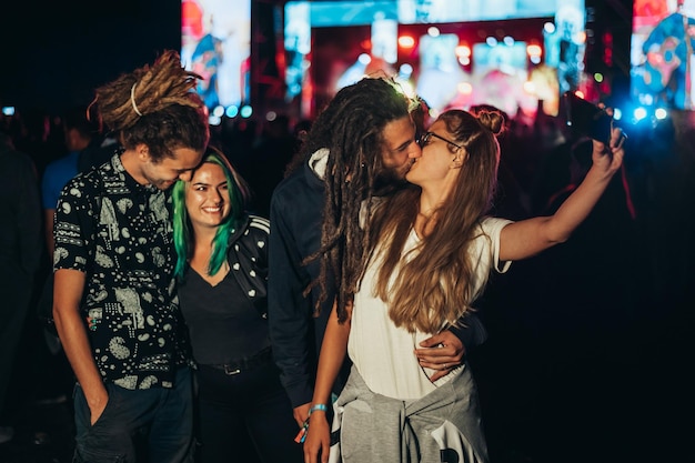 Amis au festival de musique d'été prenant le selfie avec un smartphone