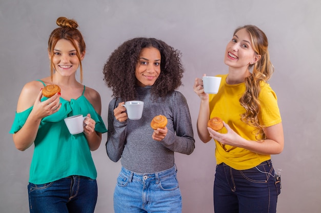 Amis au thé de l'après-midi mangeant des beignets et buvant du café avec du lait