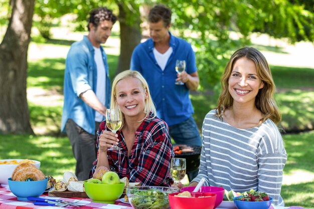 Amis ayant un pique-nique avec vin et barbecue