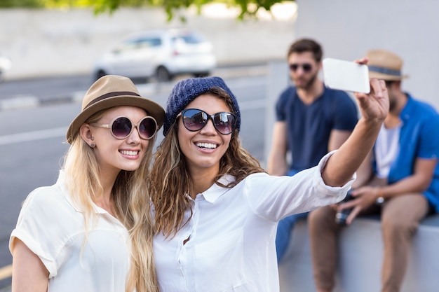 Amis branchés prenant des selfies dans les rues