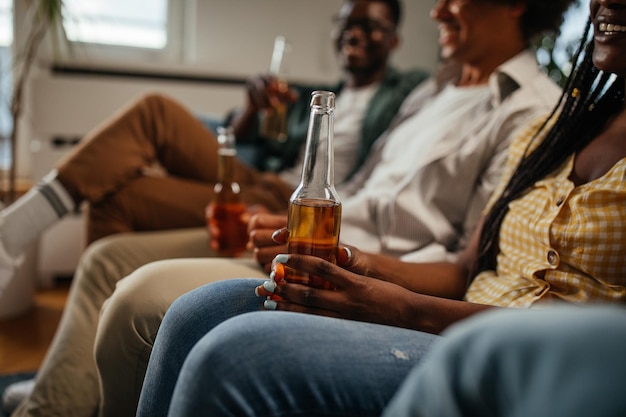 Amis buvant de la bière et s'amusant dans le salon