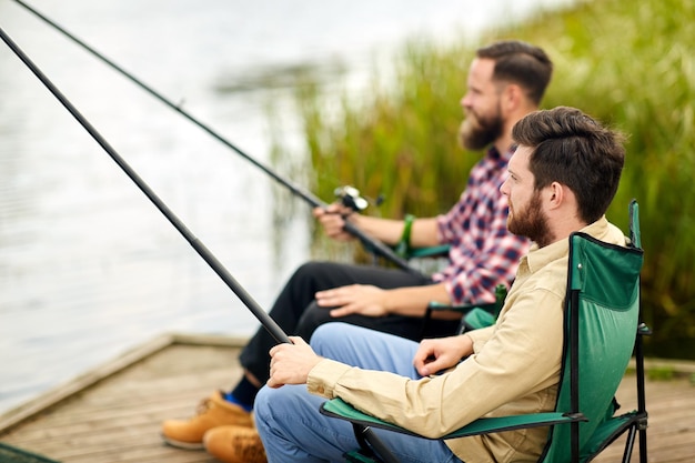 amis avec des cannes de pêche au lac ou à la rivière