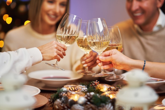 Amis célébrant la fête de Noël tenant du vin. photo de haute qualité