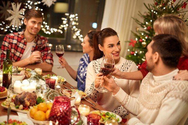 Des amis célèbrent Noël et boivent du vin.
