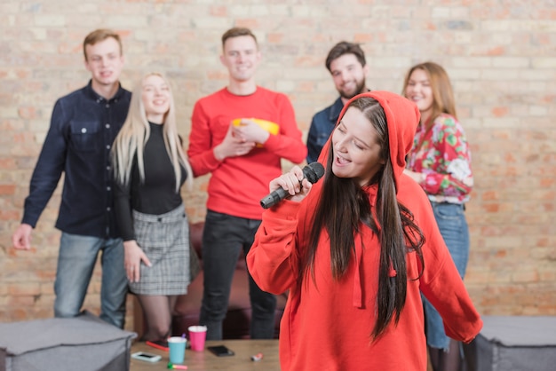 Amis chantant au karaoké lors d'une fête