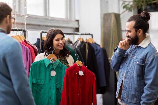 amis choisissant des vêtements dans un magasin de vêtements vintage