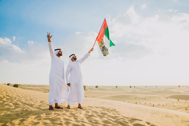 Photo des amis debout sur la plage contre le ciel