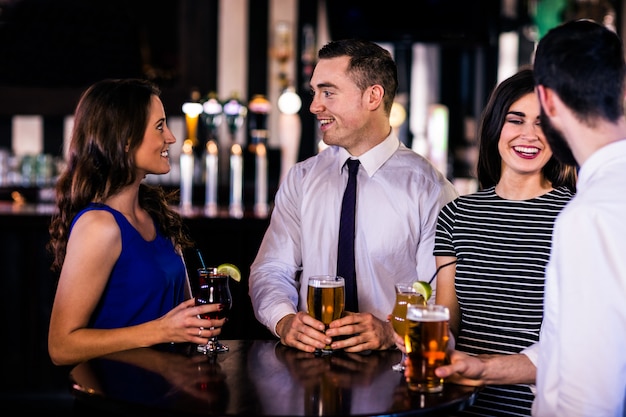 Amis discutant et prenant un verre dans un bar