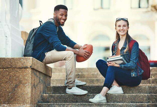 Les amis du campus de l'éducation et les étudiants de la diversité se détendent avant l'apprentissage ou le cours d'études universitaires Connaissances universitaires et portrait scolaire d'une femme et d'un homme noir sur une bourse de football